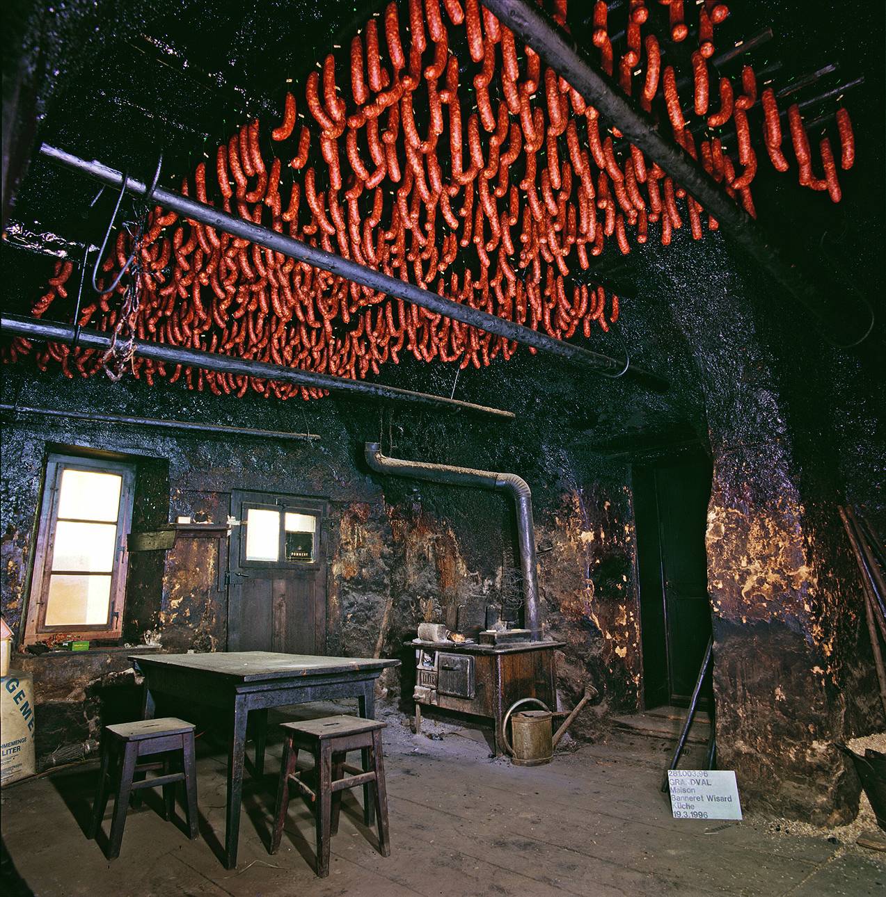 Seit um 1550 gemauerte Küche mit Möbeln und Ofen des 19. Jahrhunderts. Unter der gewölbten Decke werden im Museum Würste geräuchert. Foto: Archäologischer Dienst Bern, Badri Redha, 1996
