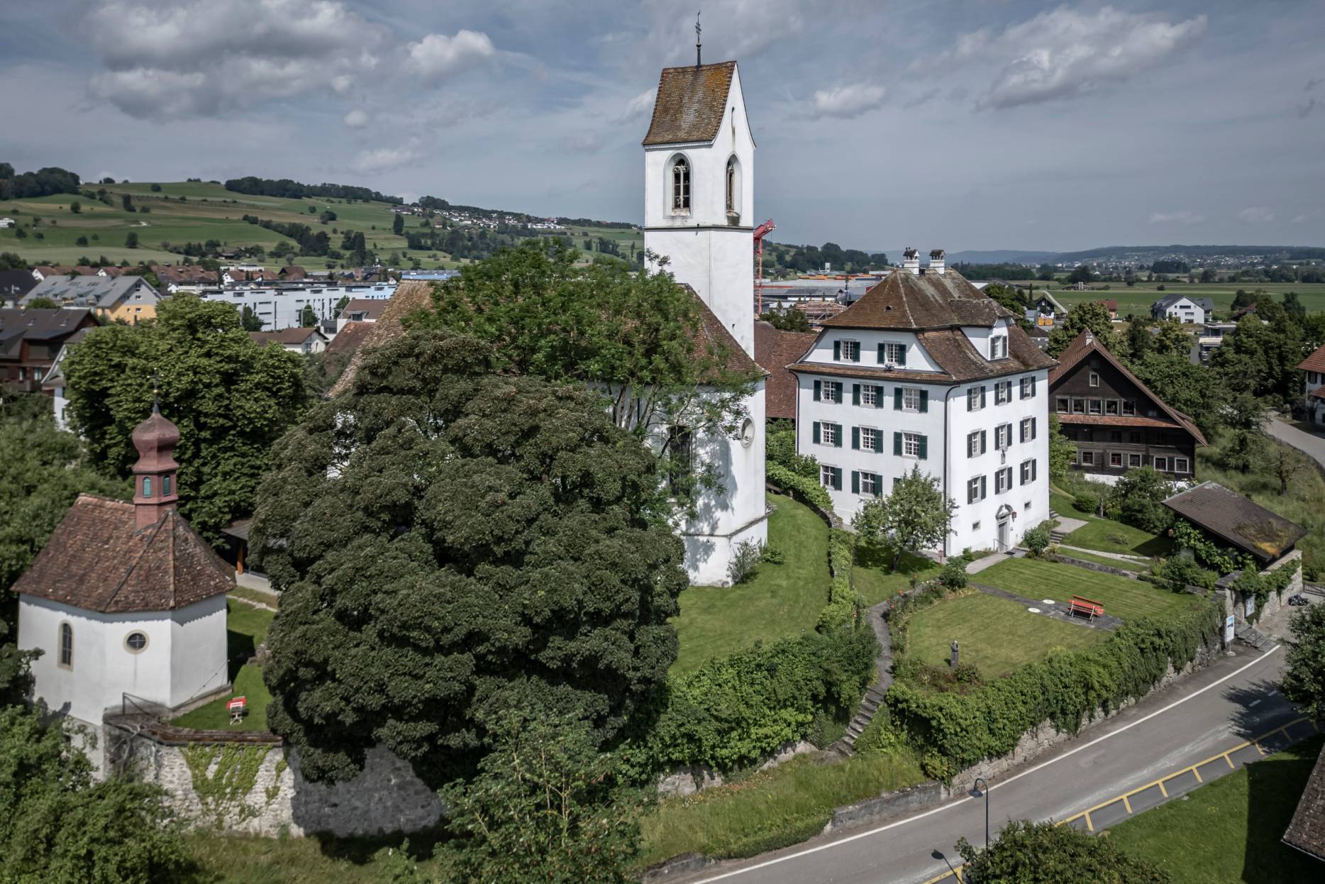 Umgebung mit Kirche Boswil. Die profanierte Kirche gehört ebenfalls der Stiftung, wird für Konzerte genutzt und erhielt 2017 ein bemerkenswertes Foyer. Foto: Elia Schneider, 2024