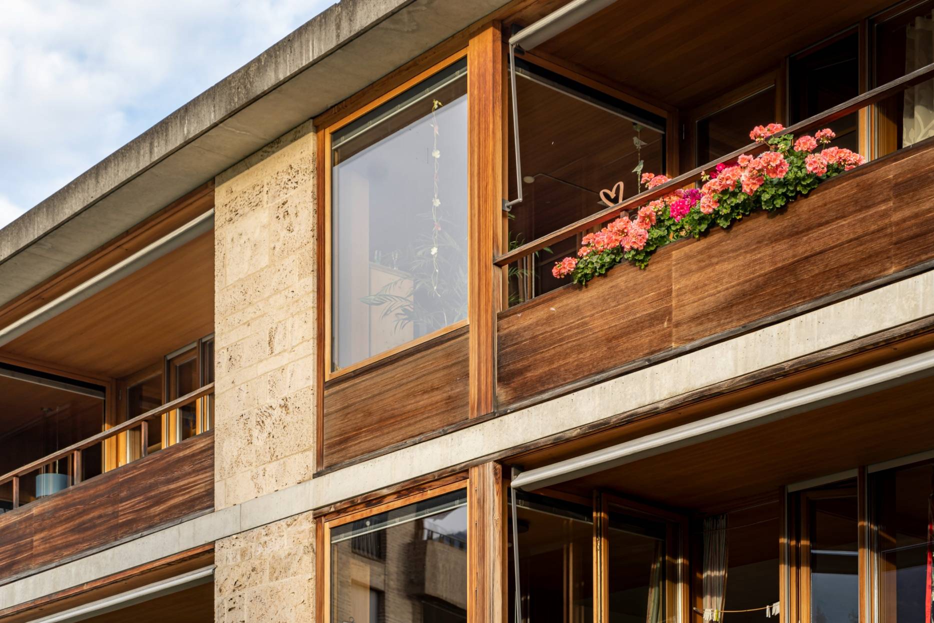 Fassade West mit Balkonelement aus Lärchenholz. Foto: Elia Schneider, 2022