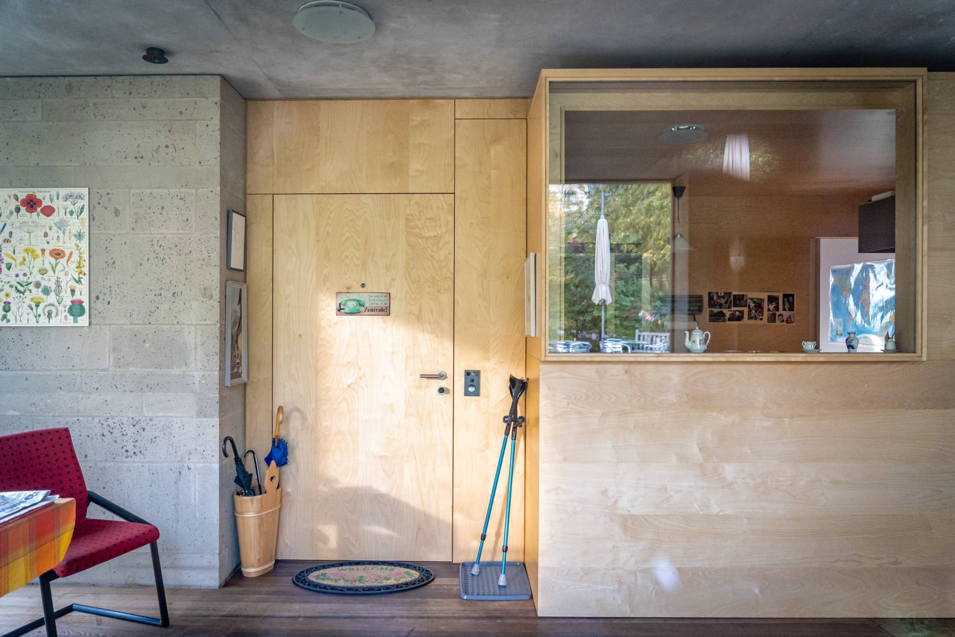 Wohnungseingang zwischen Holzkubus und Nasszellenblock aus Travertin. Foto: Elia Schneider, 2022