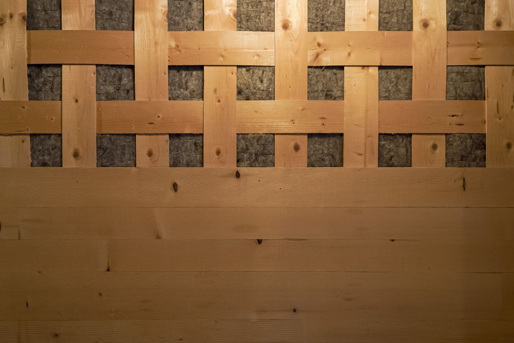 Detail Wandverkleidung aus gewobenen Holzlamellen und Wolle zur Verbesserung der Akustik. Foto: Elia Schneider, 2022