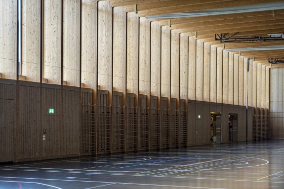 Brettschichtholzrahmen rhythmisieren den Innenraum. Foto: Elia Schneider, 2022
