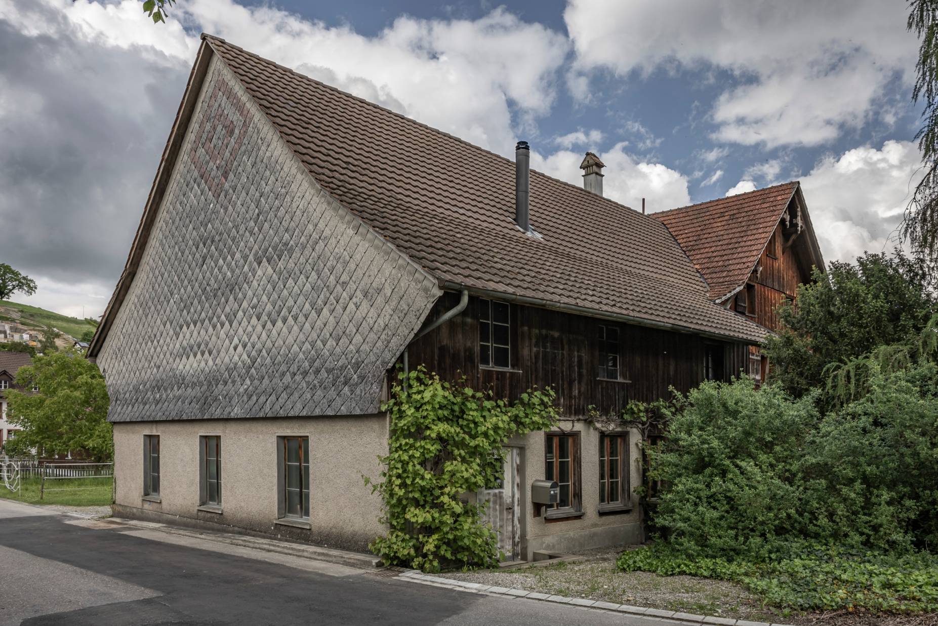 Stallscheune mit Eternitverkleidung der Westfassade. Foto: Elia Schneider, 2023